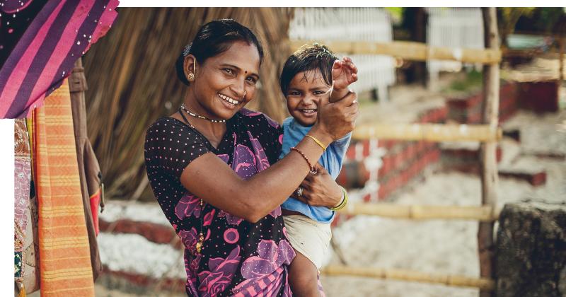 Village lady with a toddler waving to the camera